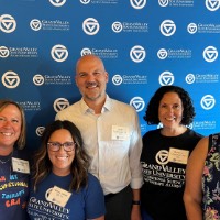 GVSU OT Alumni group take a picture together in front of GVSU Alumni Association sign